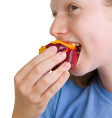 Wholesome teenage girl eating a fresh organic peach