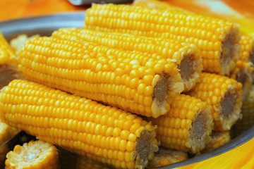 Cobs of cooked corn cooked for a picnic. Vegetarian food. Delicious cooked vegetables