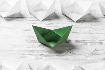 Business leadership concept with white and color paper boats on 