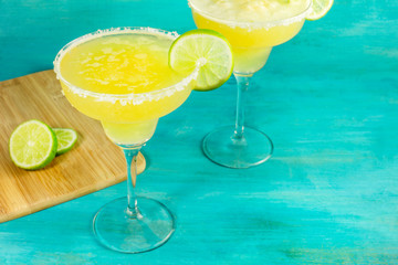 Lemon Margarita cocktails on vibrant turquoise with copyspace