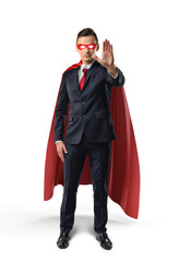 Businessman in a red cape and red eye mask with one hand raised in warning on white background.