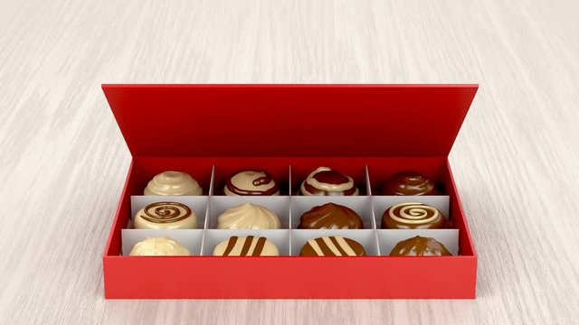Gift box with chocolate candies on wooden table