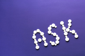 Word ASK made of white pills on purple background