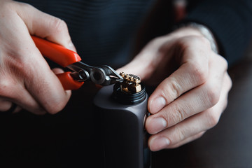 male master installs a coyle. Spiral for electronic evaporator and cigarette. Vape, vaping