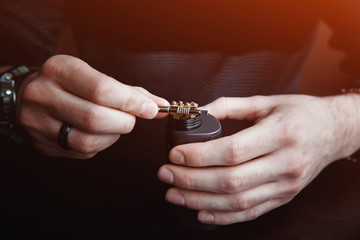 male master installs a coyle. Spiral for electronic evaporator and cigarette. Vape, vaping
