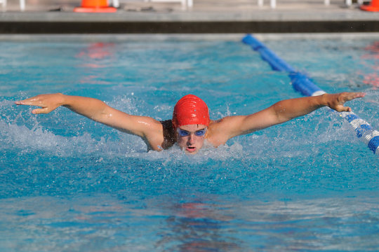 Fit Teenage Male Swimmer Swimming The Butterfly Stroke In A Swim Meet