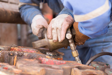 worker's hand fixing a piece of equipment