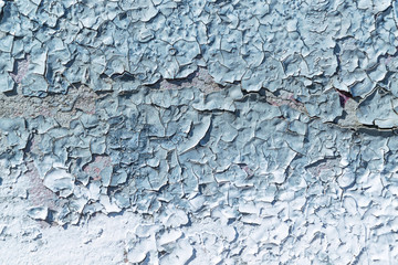 Wall painted with gray and blue paint. The paint is chipping.
