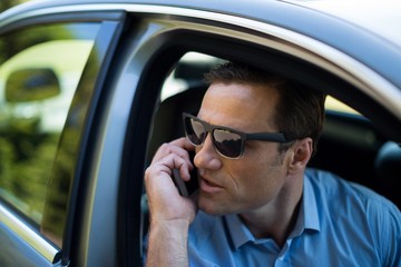Young man talking on phone while driving car