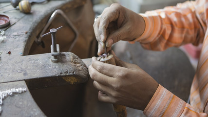Indian Jeweler making an Oriental Jewelry in workshop. Handmade traditional jewel Manufacturing in...