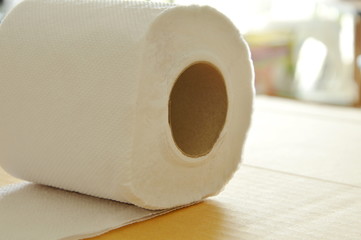 white tissue paper rolling on brown hard sheet board
