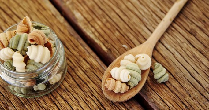 Half shell shaped pasta in jar on  wooden background