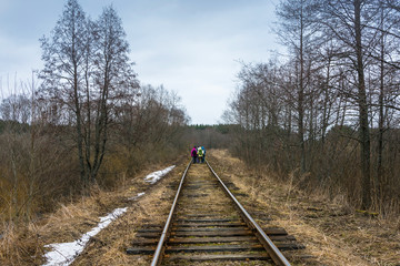 A small group of tourists walking along the railroad.