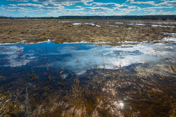 Naklejka na ściany i meble Spring landscape with bright white clouds and the reflections in the water.