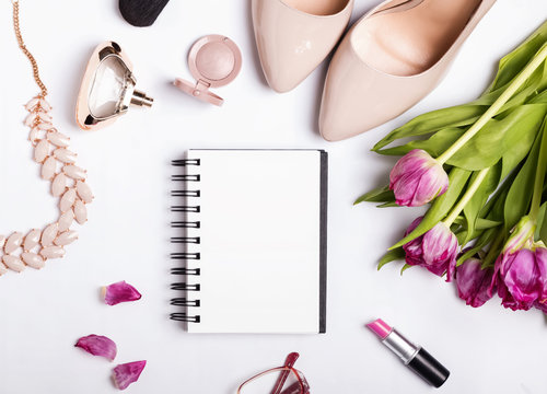 Stylish feminine accessories and blank paper notepad