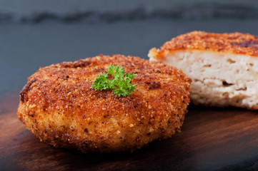 Chicken cutlet on an old wooden background, food.
