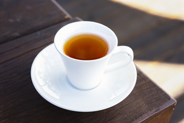 Cup of tea  on a wooden background and light