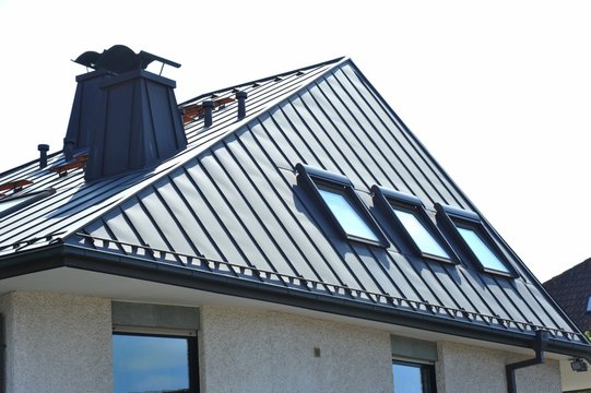 Stehfalz-Metall-Dach mit Dachfenstern und Stahl-Kaminen