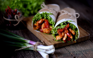 Fajitas with chicken, pepper, onion in a spicy tomato sauce, served in a tortilla.