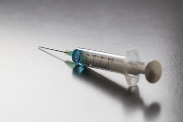 A close-up of a syringe with a blue liquid