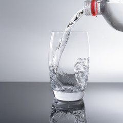 Wasserflasche beim einfüllen von Wasser in das Glas 