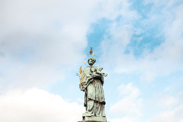 Fototapeta premium A statue of John Nepomuk (Jan Nepomucky) on the Charles bridge in Prague, Czech Republic. Architecture and sights of Prague, a postcard from Prague