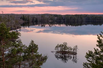 Landscape nature image of sunset over forest lake in Tyresta National Park in Stockholm, Sweden.