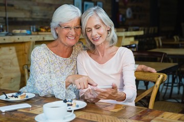 Two senior women using mobile phone