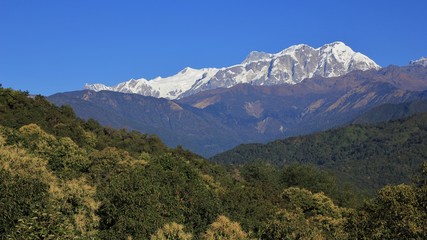 Green forests and snow capped Annapurna range. Landscape in the Himalayas, Nepal.