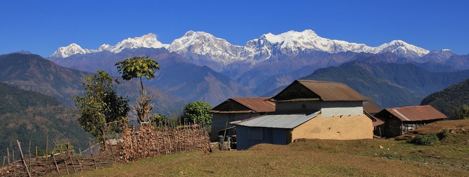 Houses near Ghale Gaun and snow capped Manaslu range. Rural scene in Nepal.
