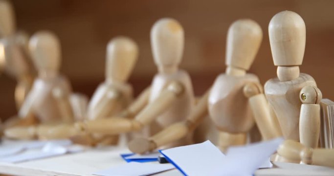 Wooden figurines having meeting in conference room