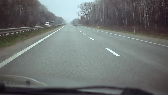 Car overtakes the truck on interurban highway. POV view from car cabin to intercity high speed traffic. Outrunning maneuver slow motion.