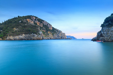Fototapeta premium Long exposure landscape of Paleokastritsa famous sand beach in close bay on Corfu island at dusk, Ionian archipelago, Greece.