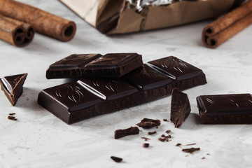 Pieces of dark chocolate with cinnamon sticks