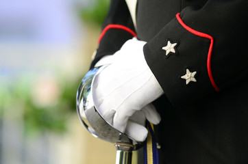 Carabiniere vestito in alta uniforme tiene con due mani la spada - obrazy, fototapety, plakaty