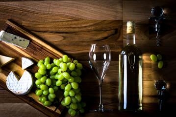 Obraz premium Wine bottles with grapes and cheese on wooden rustic background. copy space