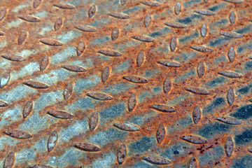 Close-up of rusty metal floor pattern with blur effect.