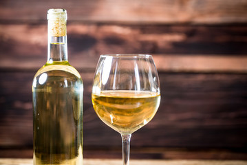 Glass bottle of wine with corks on wooden rustic table, place for typography
