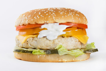 Hamburger with chicken, cheese, tomato and sauce on white background