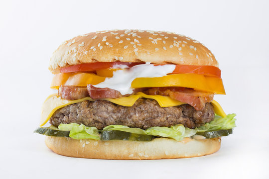 Hamburger with beef, cheese, tomato and sauce on white background
