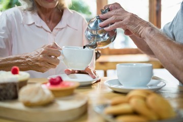 Senior man pouring tea into cup