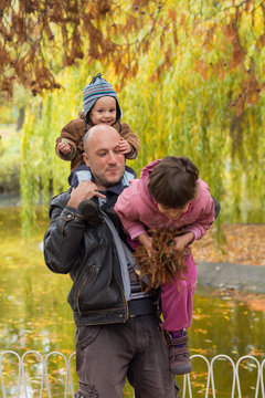 Father carrying son and daughter piggybacks