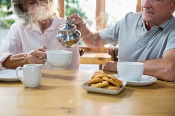 Senior man pouring tea into cup