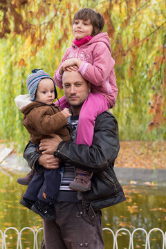 Father carrying son and daughter piggybacks
