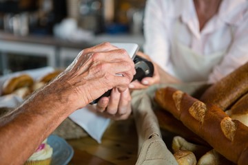 Obraz premium Customer making payment through NFC technology on mobile phone