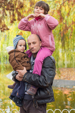 Father carrying son and daughter piggybacks
