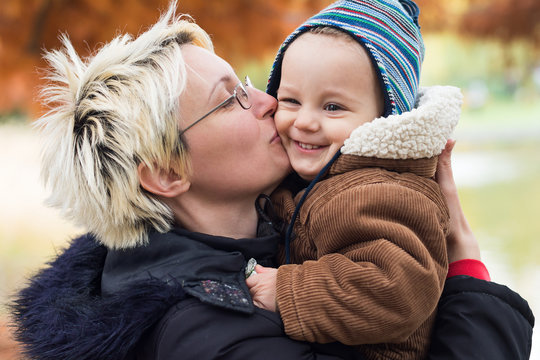 Mother kiss her son in a park