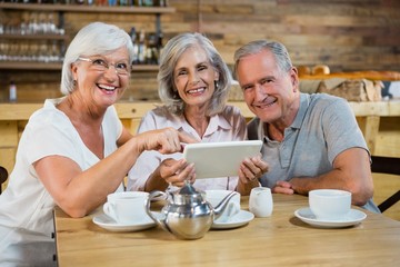 Group of senior friends using digital tablet