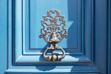 Heurtoir en fer forgé, sur une porte bleue