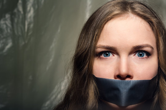 A beautiful girl with a gag in her mouth as a symbol of censorship. Silence of issues of sexual discrimination.